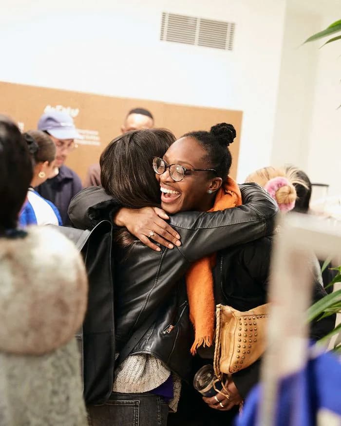 Dos compañeras se abrazan sonriendo durante un encuentro del equipo