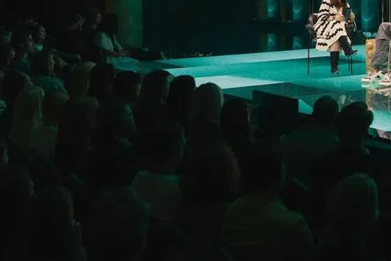 Auditorio con público frente a un escenario iluminado